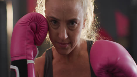 Close-up-of-female-boxer-wearing-boxing-gloves-practicing-her-punches-at-the-gym
