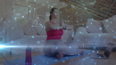 Animation-of-network-of-connections-over-woman-meditating-exercising-at-home
