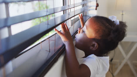 Afroamerikanisches-Mädchen-Schaut-Zu-Hause-Aus-Dem-Fenster