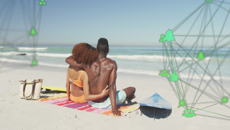 Animation-of-spinning-networks-with-social-media-digital-icons-over-couple-embracing-on-beach