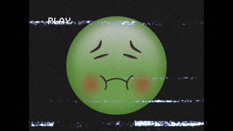 Digitale-Animation-Des-VHS-Glitch-Effekts-über-Einem-Grünen-Emoji-Mit-Krankem-Gesicht-Vor-Schwarzem-Hintergrund