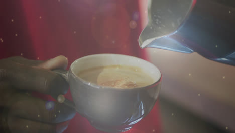 Animation-of-floating-particles-with-hands-of-a-man-pouring-milk-into-cup-of-coffee