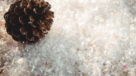 Animation-of-snow-falling-over-pine-cones-on-snow