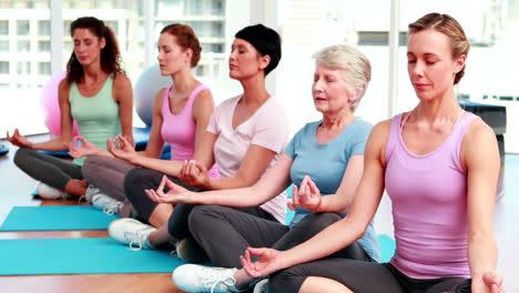 Group-of-women-in-fitness-studio-doing-yoga