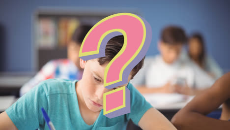 Animation-of-pink-question-mark-over-caucasian-schoolboy-writing-at-desk-in-classroom