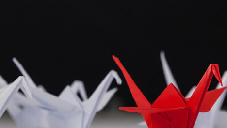 Ein-Roter-Origami-Schwan-Zwischen-Weißen-Origami-Schwänen