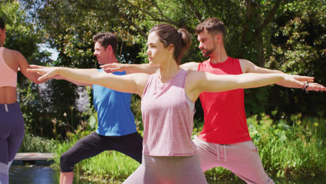 Grupo-Diverso-Practicando-Pose-De-Yoga-En-Un-Parque-Soleado-Con-Una-Instructora-Asiática-Ayudando