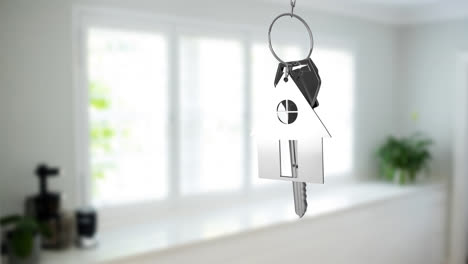 Animation-of-silver-key-with-key-with-key-ring-over-blurred-house-interior