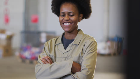Portrait-of-african-american-female-worker-looking-at-camera-and-smiling-in-warehouse