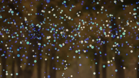 Animation-of-blue-and-white-flickering-spots-over-trees-in-background