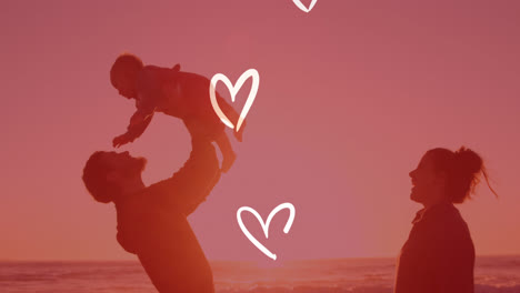 Animation-of-white-hearts-over-happy-caucasian-parents-with-child-on-beach