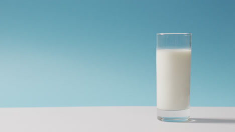Video-of-glass-of-fresh-milk-over-blue-background