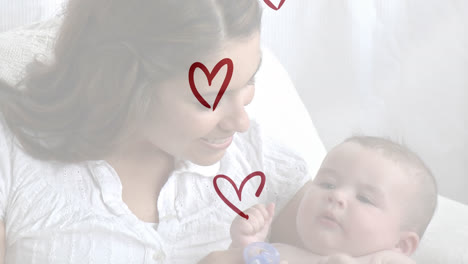 Animation-of-red-hearts-over-smiling-caucasian-woman-with-her-baby