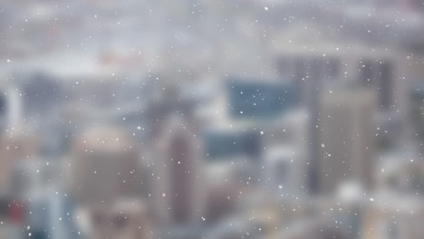 Snow-particles-falling-over-blurred-view-of-cityscape-in-background