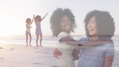 Composite-of-happy-african-american-mother-and-daughter-embracing,-and-raising-arms-walking-on-beach