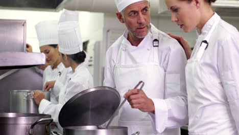 Chef-frying-vegetables-then-checking-on-colleague