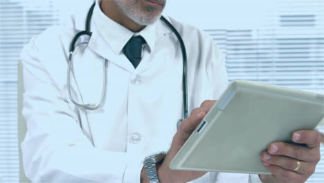 Animation-of-red-pattern-over-caucasian-male-doctor-using-tablet