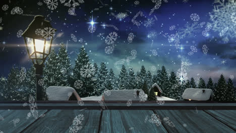 Snowflakes-floating-over-wooden-plank-against-winter-landscape-and-shining-stars-in-night-sky