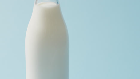 Video-of-glass-bottle-of-milk-on-blue-background