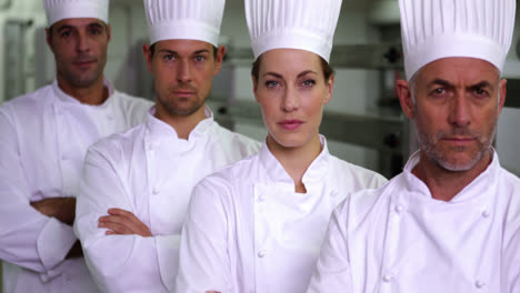 Four-stern-chefs-looking-at-camera-with-arms-crossed