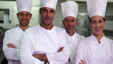 Four-happy-chefs-looking-at-camera-with-arms-crossed