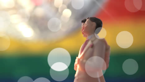 Animation-of-light-spots-over-male-gay-couple-figurines