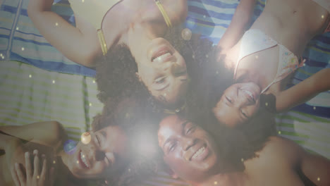 Composite-of-sunlight-and-lens-flare-over-happy-african-american-family-lying-on-beach-waving