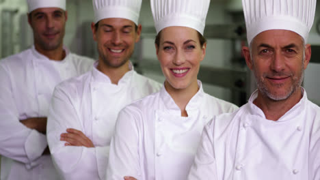 Four-cheerful-chefs-looking-at-camera-with-arms-crossed