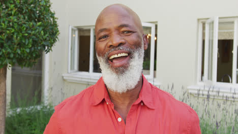 Portrait-of-senior-smiling-african-american-man-looking-at-camera-in-garden