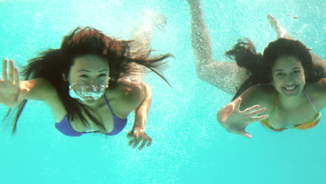 Happy-friends-waving-at-camera-underwater