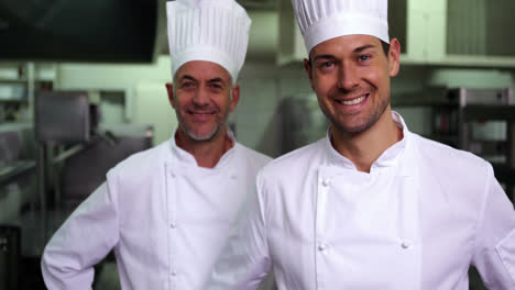 Two-smiling-chefs-giving-thumbs-up-to-camera