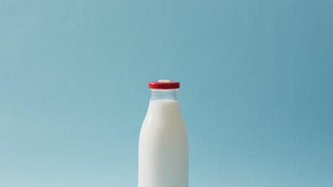 Video-Einer-Glasflasche-Milch-Auf-Blauem-Hintergrund