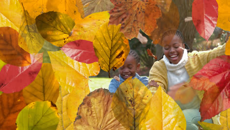 Animation-Von-Herbstblättern-über-Einer-Afroamerikanischen-Familie,-Die-Im-Park-Blätter-Wirft