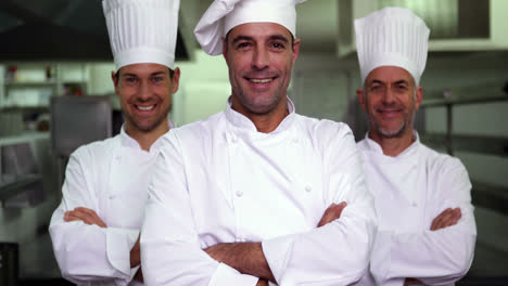 Three-smiling-chefs-looking-at-camera-making-ok-sign