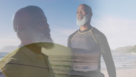 Komposit-Aus-Einem-älteren-Afroamerikaner,-Der-Die-Arme-Ausstreckt-Und-Ein-Surfbrett-Am-Sonnigen-Strand-Trägt