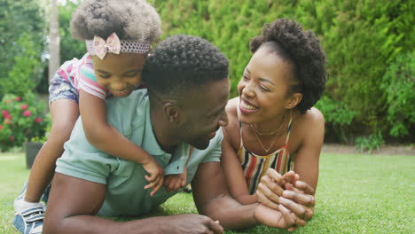 Glückliches-Afroamerikanisches-Paar-Mit-Zwei-Töchtern,-Die-Im-Garten-Spielen