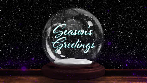 Shooting-star-around-seasons-greeting-text-in-a-snow-globe-on-wooden-surface-on-black-background