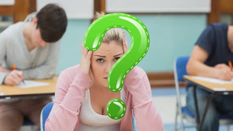 Animation-of-green-question-mark-over-stressed-female-highschool-student-at-desk-in-classroom