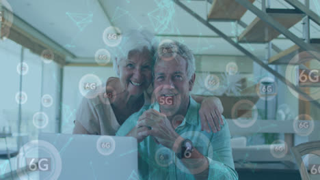 Animation-of-network-of-connections-with-icons-over-senior-caucasian-couple-using-laptop