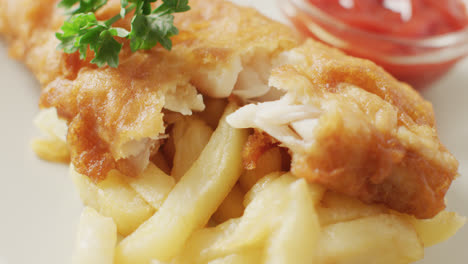 Video-close-up-of-fish-and-chips-with-parsley-and-bowl-of-ketchup-dip