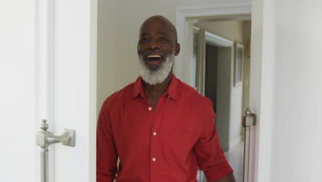 Porträt-Eines-Lächelnden-Afroamerikanischen-Mannes,-Der-In-Die-Kamera-Blickt-Und-Die-Tür-öffnet
