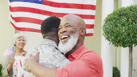 Afroamerikanischer-Soldat-Umarmt-Seinen-Lächelnden-Vater-über-Familie-Und-Amerikanische-Flagge