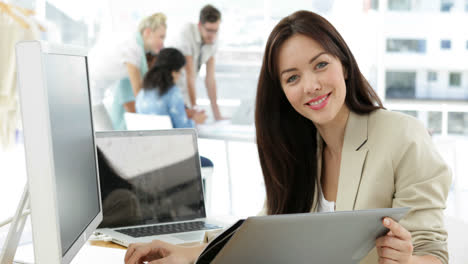 Woman-working-at-her-desk-looking-at-folder