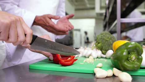 Chef-slicing-vegetables-on-a-green-board
