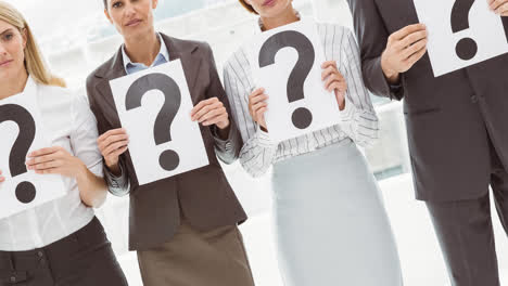 Confused-group-of-caucasian-businessmen-and-businesswomen-holding-question-mark-signs