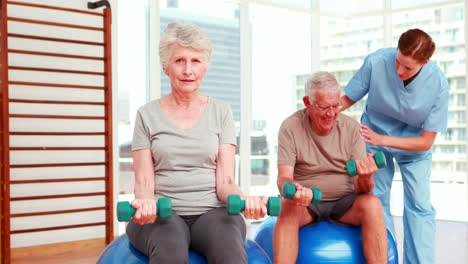 Two-senior-citizens-exercising-with-physiotherapist