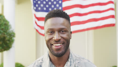 Portrait-of-african-american-male-soldier-smiling-over-american-flag