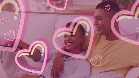 Animation-of-hearts-over-happy-biracial-male-gay-couple