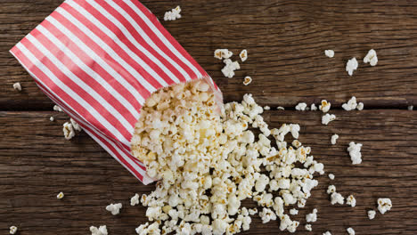 Animation-of-box-of-popcorn-over-wooden-table