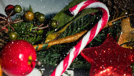 Animation-of-snow-falling-over-candy-cane-christmas-decoration